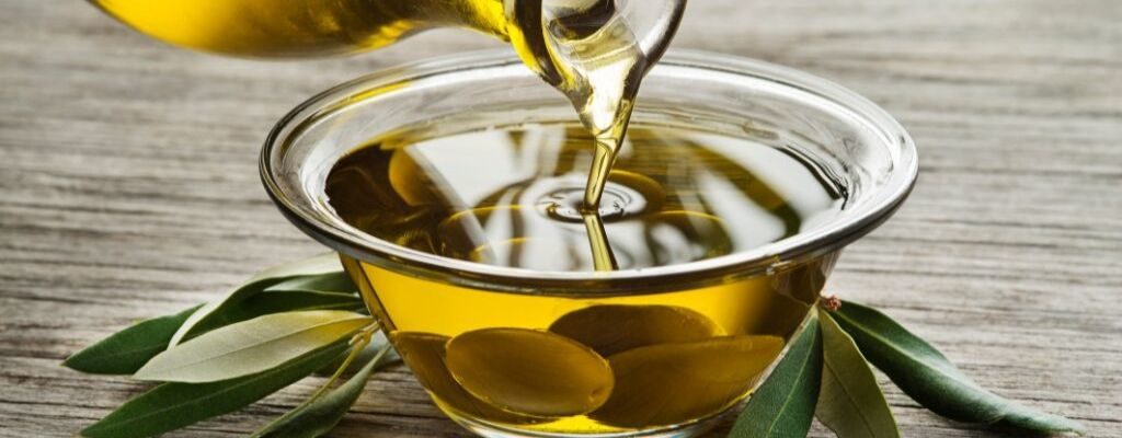 pouring olive oil to a glass bowl