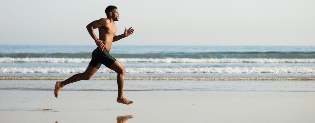 man running barefoot on sand