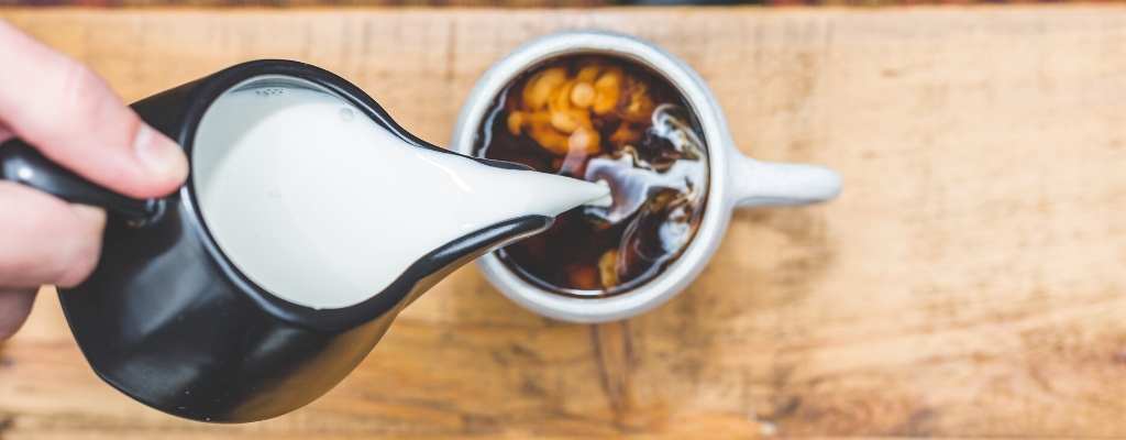 pouring milk in coffee